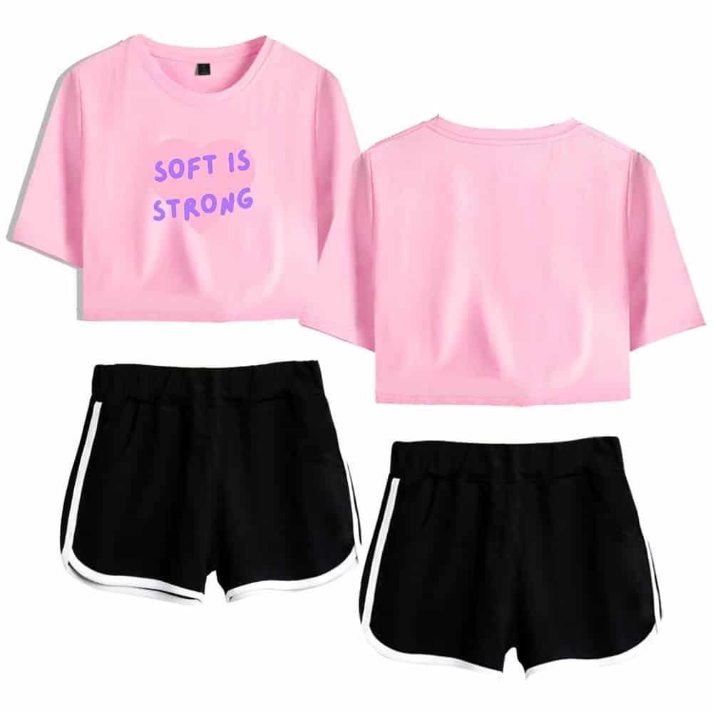 Pink crop top with "Soft is Strong" text, paired with black athletic shorts with white trim, affordable high-quality casual summer outfit.