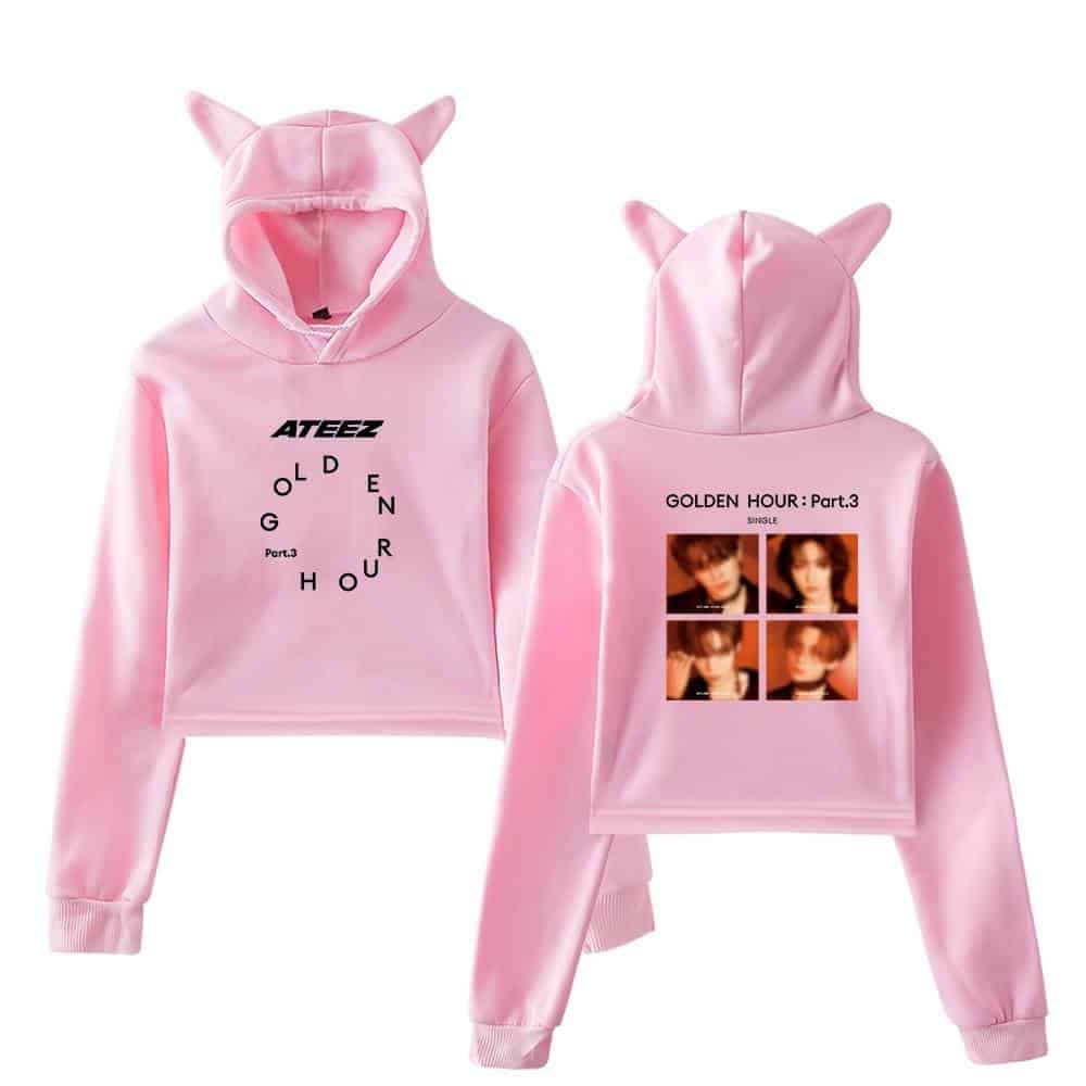Soft pink hoodie with fun animal ears, featuring bold text and popular K-pop group images, perfect for casual wear and unique style.