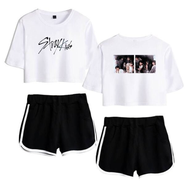 White graphic crop top with "Stray Kids" text and black shorts with white side stripes.