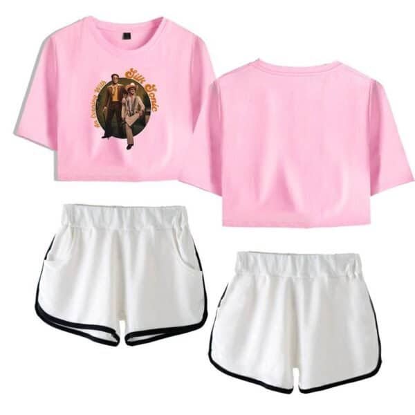 Pink graphic crop top and white athletic shorts with black trim, casual and stylish, suitable for sports or relaxed outings.
