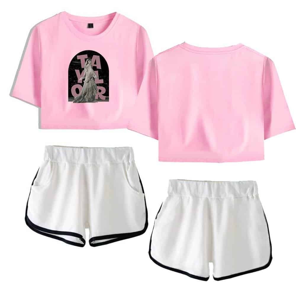 Pink cropped t-shirt with graphic "travel" design and white shorts with black trim, casual high-quality merchandise.